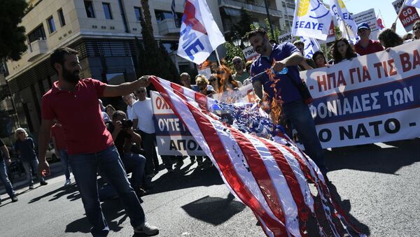 Um dos grupos de manifestantes se reuniu em frente à embaixada dos EUA em Atenas, onde queimaram uma bandeira americana - Sputnik Brasil