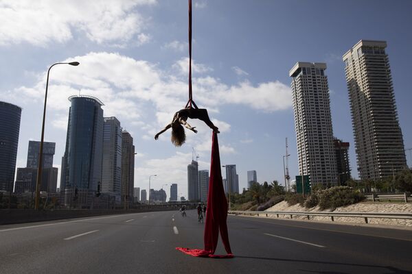 Equilibrista israelense atuando sobre uma estrada em Tel-Aviv durante a festa judaica do Dia da Expiação - Sputnik Brasil