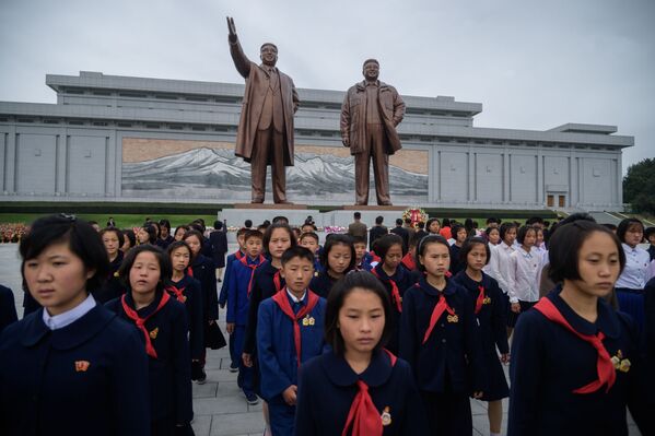 Estudantes em frente das estátuas dos líderes norte-coreanos Kim Il-sung e Kim Jong-il durante o 74º aniversário da fundação do Partido dos Trabalhadores da Coreia - Sputnik Brasil