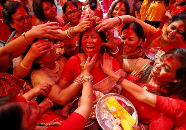 Mulheres indianas no festival da deusa Durga aplicando pó vermelho no rosto - Sputnik Brasil