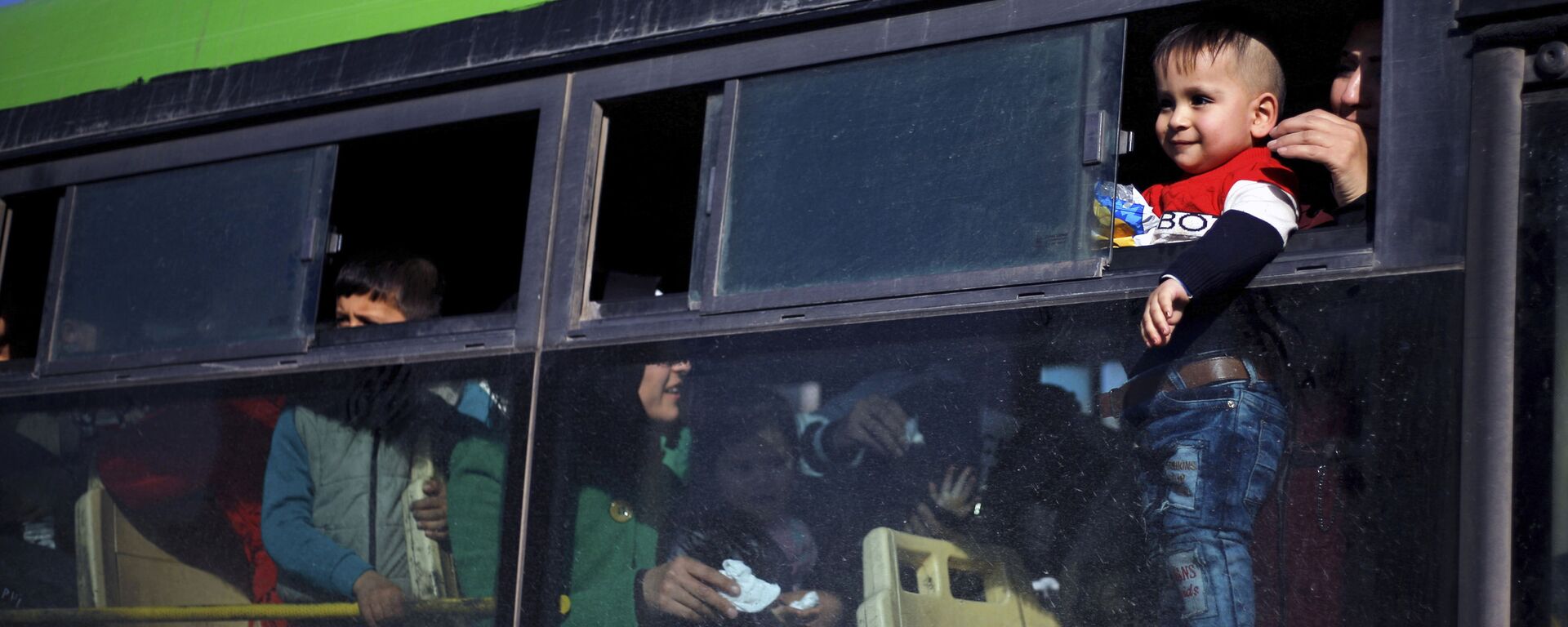 Criança refugiada olha pela janela do ônibus que a leva de volta para a casa, na Síria, em janeiro de 2019 - Sputnik Brasil, 1920, 10.03.2026