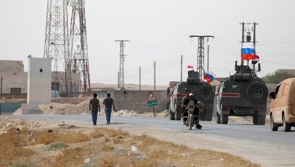 Bandeiras da Rússia e da Síria em veículos militares perto da cidade de Manbij - Sputnik Brasil