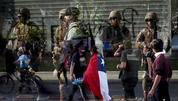 Reflexo de soldados em vidraça enquanto manifestantes passam em frente durante protestos no Chile em 21 de outubro de 2019. - Sputnik Brasil