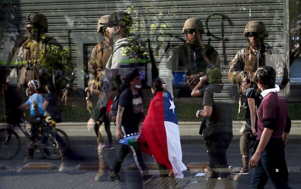 Reflexo de soldados em vidraça enquanto manifestantes passam em frente durante protestos no Chile em 21 de outubro de 2019. - Sputnik Brasil