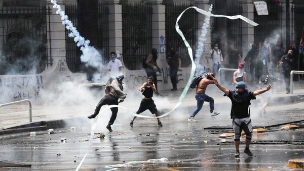 Manifestantes são atingidos por bombas de gás lacrimogêneo durante protestos e depredações no Chile - Sputnik Brasil