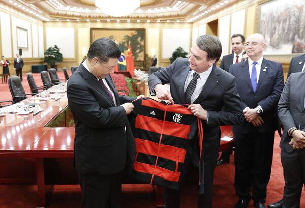 Presidente do Brasil, Jair Bolsonaro, oferece camisa do Flamengo ao presidente chinês, Xi Jinping, no fim da cerimônia de assinatura no Grande Salão do Povo, em Pequim - Sputnik Brasil