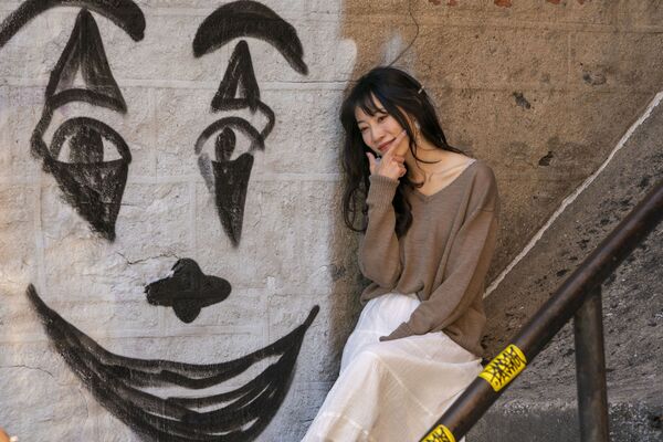 Mulher posa ao lado de um grafite do Coringa na escadaria que se tornou famosa em Nova York
 - Sputnik Brasil