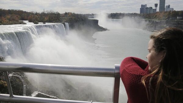 Uma turista olhando para as Cataratas do Niágara na fronteira entre os EUA e o Canadá - Sputnik Brasil