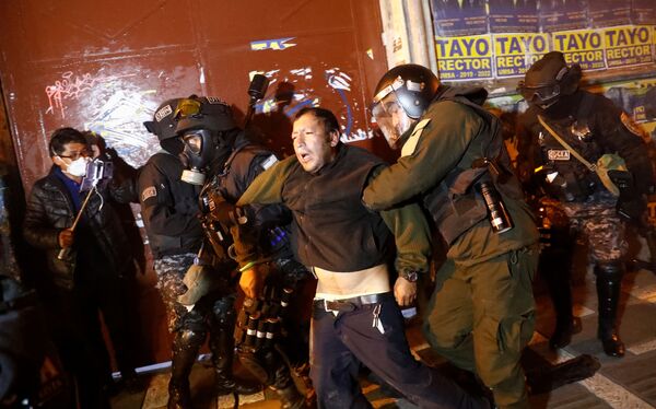 Homem ferido é acudido pela polícia, durante conflito entre manifestantes na cidade de La Paz, nesta terça-feira (5) - Sputnik Brasil