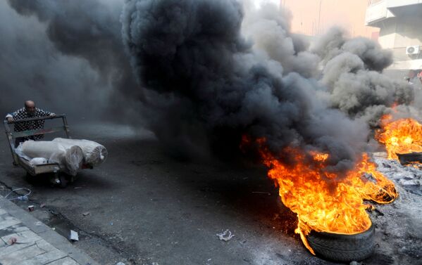 Pneus em chamas durante protestos contra o governo iraquiano na capital Bagdá - Sputnik Brasil