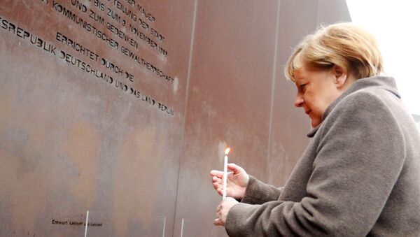 Chanceler alemã Angela Merkel deposita uma vela durante as celebrações dos 30 anos da queda do Muro de Berlim - Sputnik Brasil