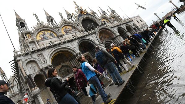 Turistas andam sobre passadiço improvisado durante inundação na Praça de San Marco, Veneza - Sputnik Brasil