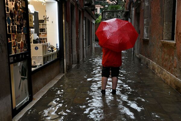 Turista passeia com guarda-chuva por uma das ruas de Veneza - Sputnik Brasil
