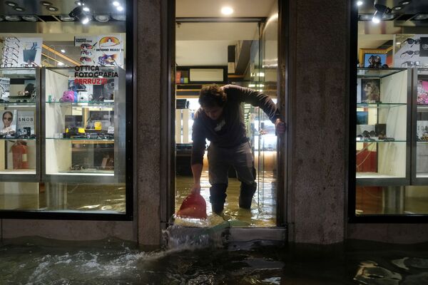 Trabalhador de ótica em Veneza remove a água do interior da loja - Sputnik Brasil