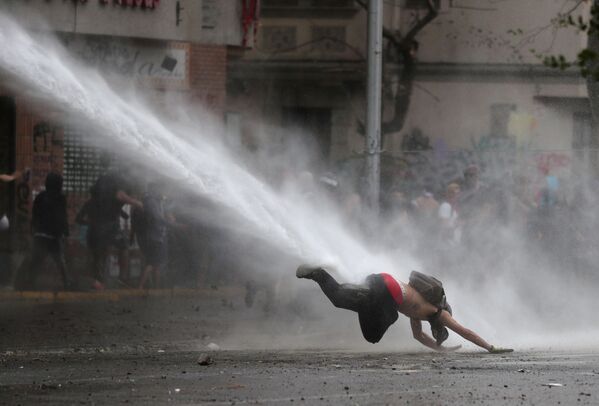 Manifestante é atingido por jato de água durante protesto contra o governo chileno, em Santiago, Chile, 11 de novembro de 2019 - Sputnik Brasil