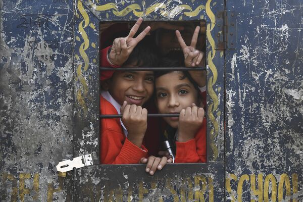 Crianças sorriem durante caminho de volta para casa após a escola dentro de um riquixá na capital indiana de Nova Deli - Sputnik Brasil