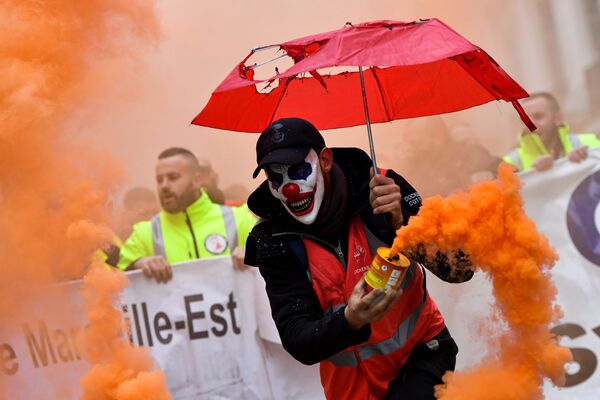 Homem em máscara de palhaço com bomba de fumaça durante protestos contra reforma do sistema de aposentadoria na cidade de Marselha, França - Sputnik Brasil