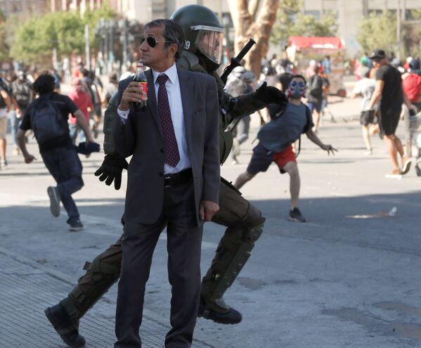 Homem com garrafa de Coca-Cola durante um protesto antigovernamental em Santiago, Chile - Sputnik Brasil