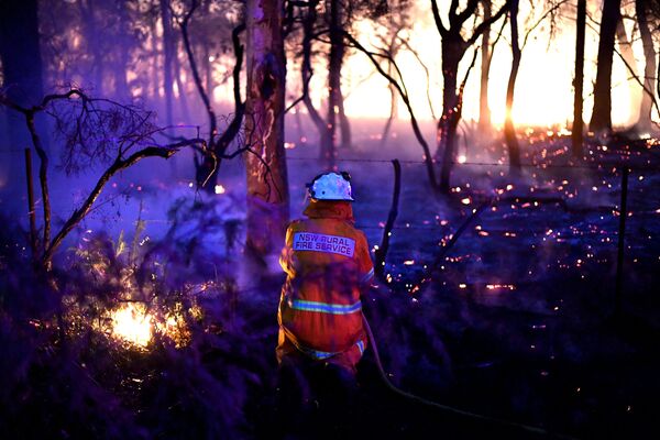 Bombeiro usando técnica para mudar a direção do fogo durante incêndio na Austrália - Sputnik Brasil