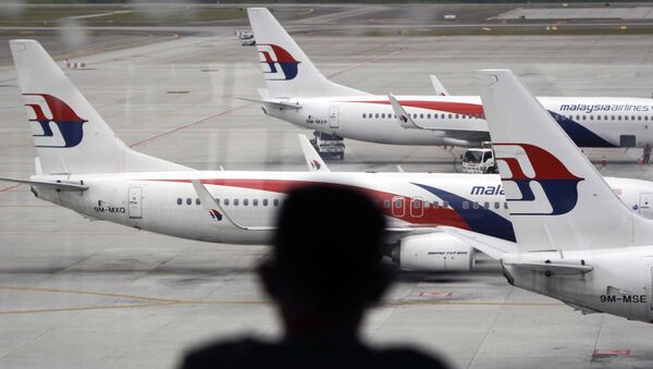 Homem olhando para aviões da Malaysia Airlines no aeroporto de Kuala Lumpur (foto de arquivo) - Sputnik Brasil