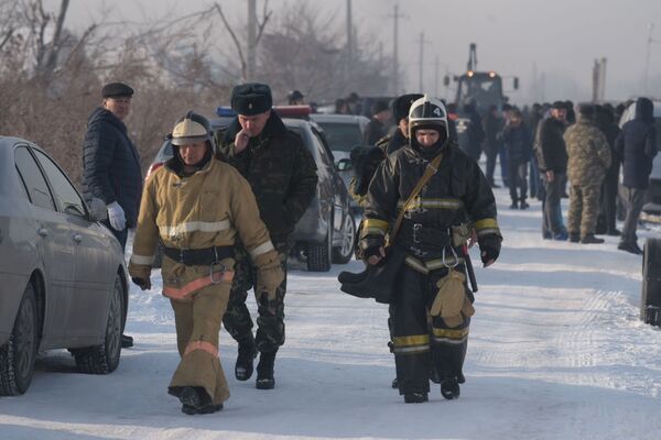Equipe do serviço de emergência cazaque caminha perto do local do acidente aéreo no Cazaquistão, 27 de dezembro de 2019 - Sputnik Brasil