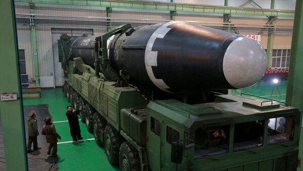 Kim Jong-un visto ao lado de míssil balístico intercontinental Hwasong-15, após testes bem sucedidos, em novembro de 2017 (foto de arquivo) - Sputnik Brasil