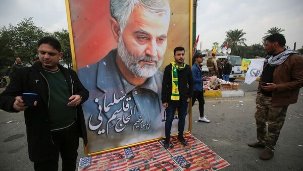 Militantes ao lado de quadro com o rosto do general iraniano Qasem Soleimani durante seu funeral - Sputnik Brasil