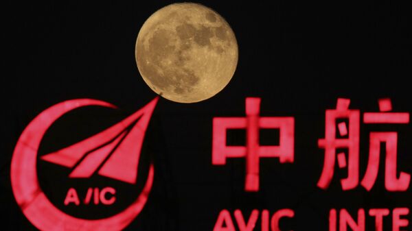 Lua ao lado do logo da Corporação da Indústria de Aviação da China (Avic, na sigla em inglês), em Pequim - Sputnik Brasil