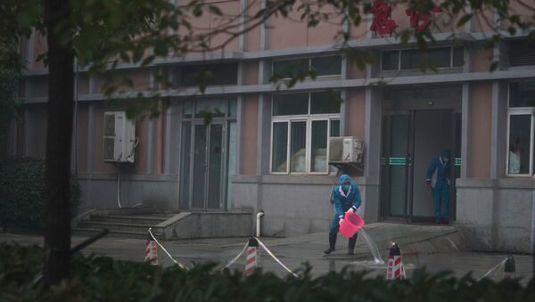 Funcionários do hospital lavam a entrada de emergência do Centro de Tratamento Médico de Wuhan, onde alguns infectados com um novo vírus estão sendo tratados, em Wuhan, China, quarta-feira, 22 de janeiro de 2020. - Sputnik Brasil