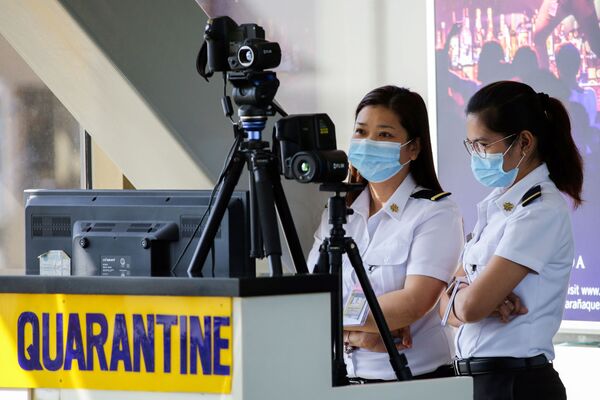 Funcionárias escaneiam passageiros no Aeroporto Internacional Ninoy Aquino, nas Filipinas - Sputnik Brasil
