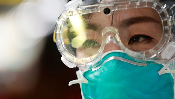 Funcionária de aeroporto usa máscara e óculos para se proteger de surto de coronavírus (foto de arquivo) - Sputnik Brasil