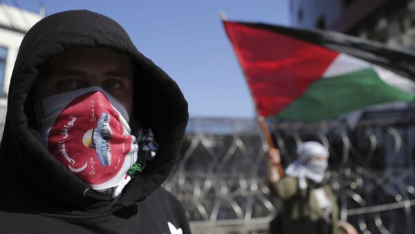 Manifestante cobre o rosto durante protestos contra o plano apresentado pela Casa Branca para a questão israelo-palestina, próximo da representação dos EUA em Beirute, no Líbano, em 2 de fevereiro de 2020 - Sputnik Brasil