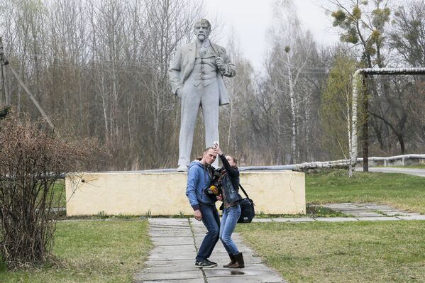 Jornalistas fazem selfies com monumento de Lenin ao fundo, em Chernobyl - Sputnik Brasil