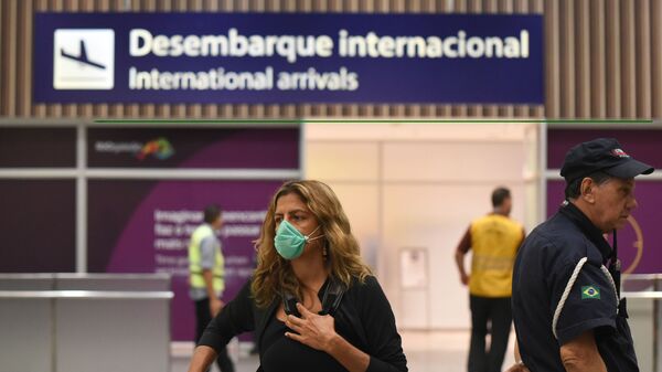 Turistas e funcionários do Aeroporto Internacional Tom Jobim, no Rio de Janeiro, usam máscaras para prevenir o contágio com o coronavírus - Sputnik Brasil