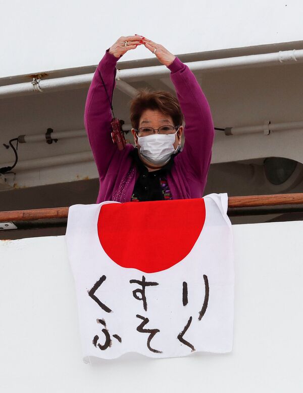 Paciente pendura a bandeira japonesa com a mensagem medicamentos em falta, no navio Diamond Princess, colocado em quarentena em função do coronavírus - Sputnik Brasil