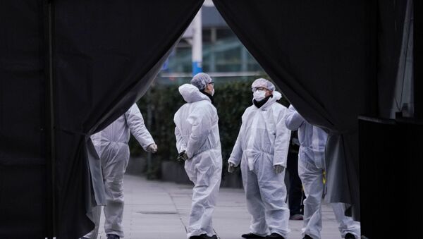 Funcionários com máscaras de proteção são vistos na estação ferroviária de Xangai, na China, enquanto o país é atingido pelo surto do novo coronavírus, 7 de fevereiro de 2020 - Sputnik Brasil