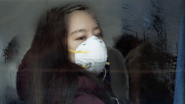 Mulher usa máscara de proteção em ônibus, na capital chinesa Pequim (foto de arquivo) - Sputnik Brasil