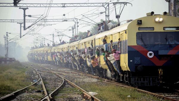 Passageiros indianos se penduram nas portas de vagão de trem superlotado - Sputnik Brasil