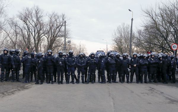 Policiais ucranianos formam barreira para impedir que manifestantes avancem sobre ônibus com passageiros evacuados da China, em Novye Sanzhany, na Ucrânia, em 20 de fevereiro de 2020 Policiais ucranianos formam barreira para impedir que manifestantes avancem sobre ônibus com passageiros evacuados da China, em Novye Sanzhany, na Ucrânia, em 20 de fevereiro de 2020 - Sputnik Brasil