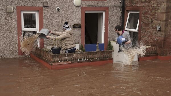 Homens tentam controlar o fluxo de água da enchente em uma propriedade de Appleby-in-Westmorland após a tempestade Ciara atingir o Reino Unido, em Cumbria, Inglaterra, em 9 de fevereiro de 2020 - Sputnik Brasil