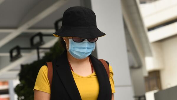 Mulher chinesa deixa Tribunal de Singapura usando máscara para se proteger do coronavírus (imagem referencial) - Sputnik Brasil