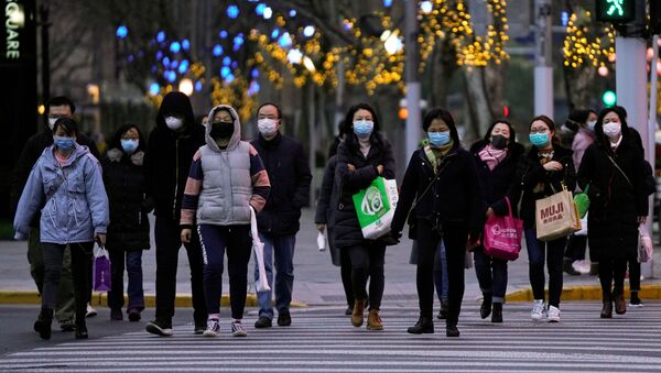 Pessoas usando máscaras protetoras caminham nas ruas em meio a surto do novo coronavírus, em Xangai, China, 4 de março de 2020 - Sputnik Brasil