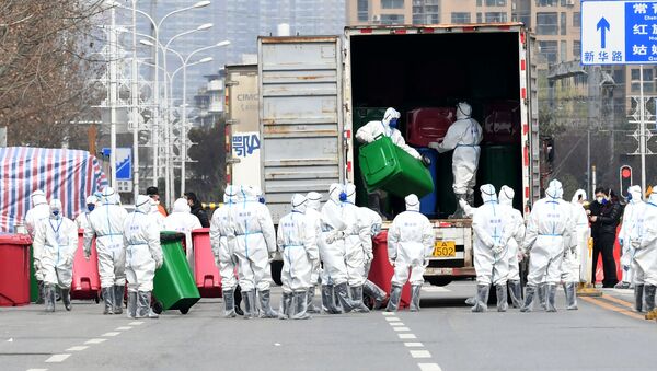 Trabalhadores em trajes de proteção participam da desinfecção do mercado de frutos do mar de Wuhan, onde se acredita ter surgido o novo coronavírus, na província de Hubei, China, 4 de março de 2020 - Sputnik Brasil