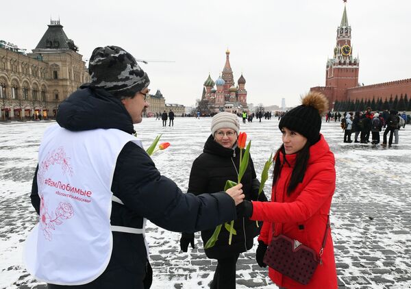 Voluntário oferece flores a mulheres na Praça Vermelha, em Moscou - Sputnik Brasil