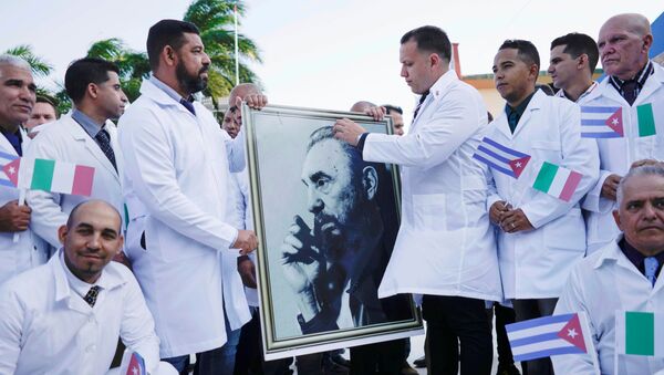 Médicos cubanos a caminho da Itália seguram imagem do falecido presidente cubano, Fidel Castro, durante cerimônia de despedida em Havana, 21 de março de 2020 - Sputnik Brasil