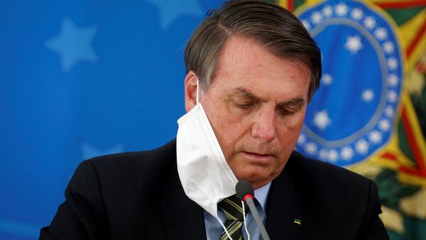 Presidente do Brasil, Jair Bolsonaro, ajeita máscara durante coletiva de imprensa sobre medidas federais para conter coronavírus, Brasília, 18 de março de 2020 - Sputnik Brasil