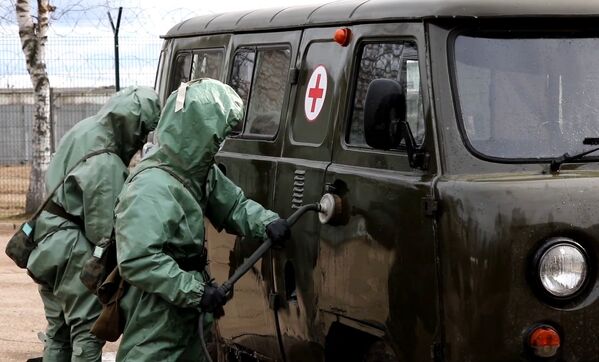 Militares das Tropas de DQBRN realizam limpeza de veículo médico, conforme o procedimento para combate a situações epidemiológicas virais. - Sputnik Brasil