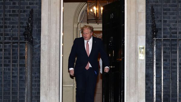 Primeiro-ministro do Reino Unido, Boris Johnson, sai de sua residência oficial, em Downing Street, durante aplausos ao pessoal do serviço público de saúde, em 26 de março de 2020 - Sputnik Brasil