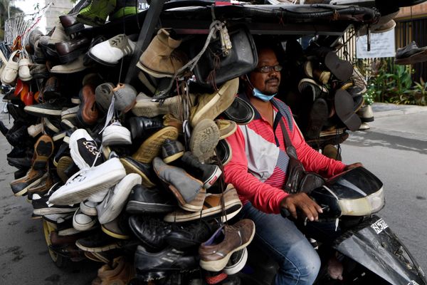 Homem anda de moto transportando sapatos de segunda mão para venda em rua no Camboja, 24 de março de 2020 Homem anda de moto transportando sapatos de segunda mão para venda em rua no Camboja, 24 de março de 2020 - Sputnik Brasil