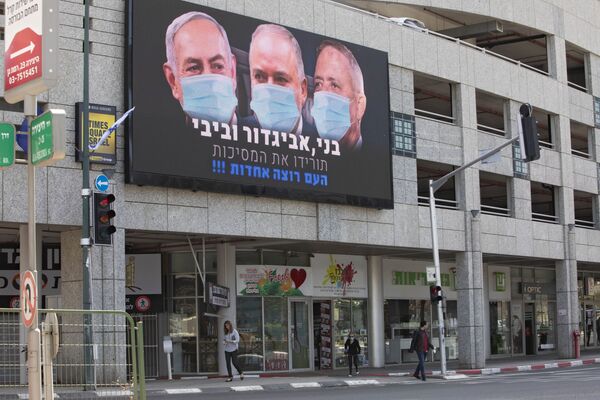 Outdoor mostra o primeiro-ministro israelense Benjamin Netanyahu, o ex-ministro da Defesa israelense Avigdor Lieberman e o líder do partido oposicionista Azul e Branco Benny Gantz usando máscaras em cidade israelense perto de Tel Aviv, 29 de março de 2020 - Sputnik Brasil